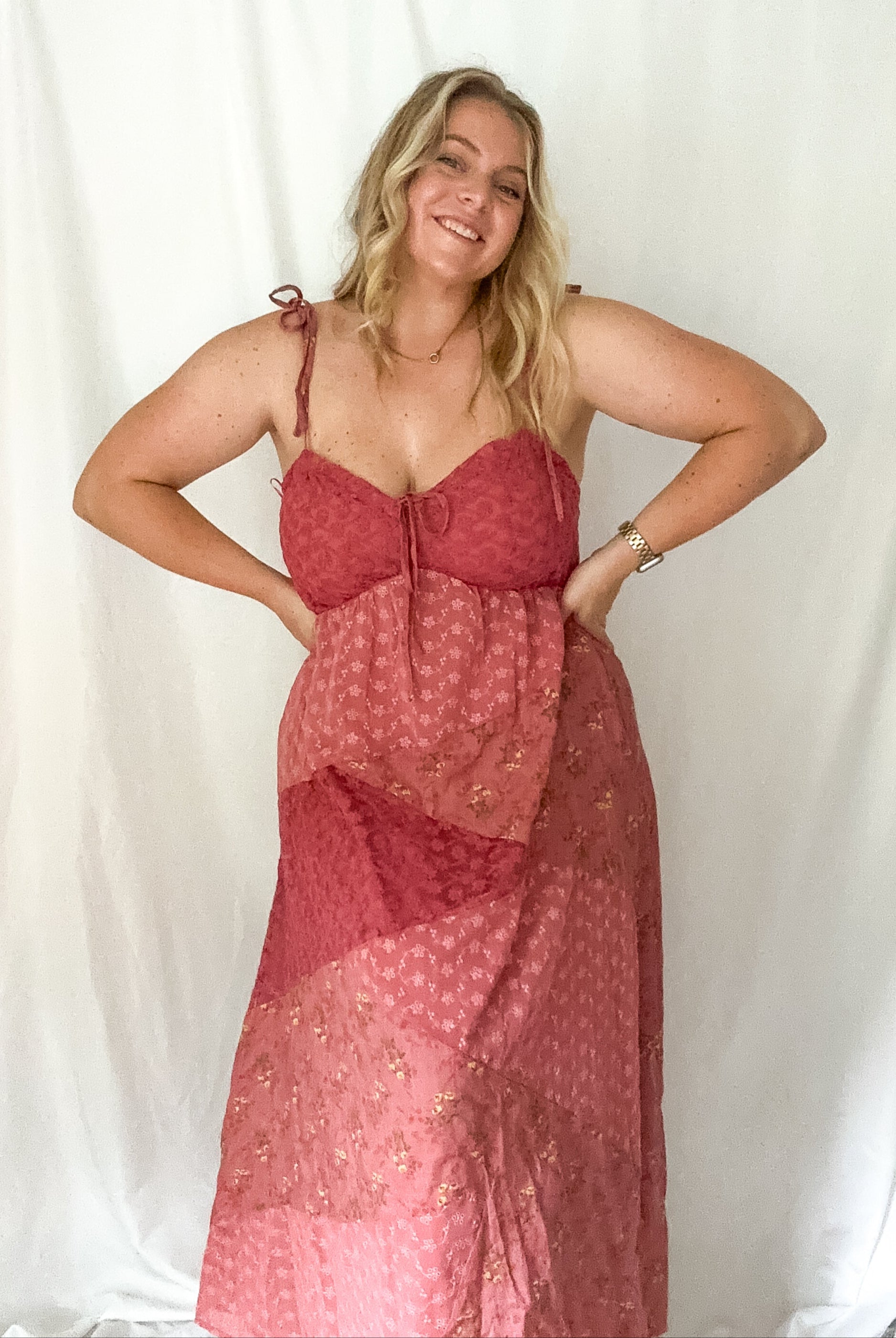 Woman wearing a red patterned dress against a white background