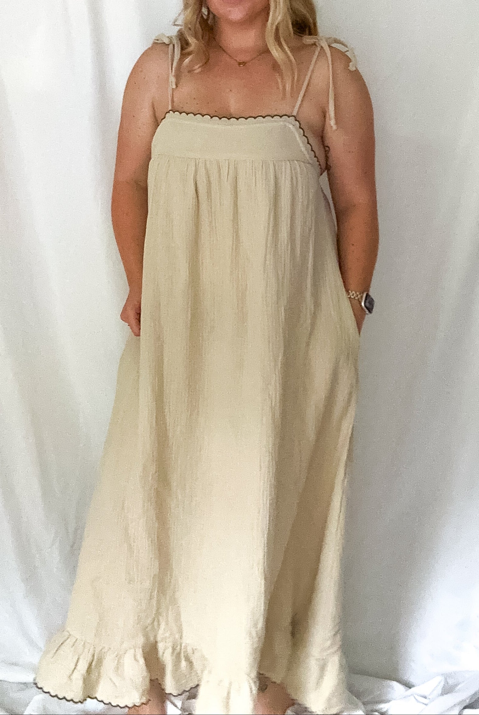 Woman wearing a beige dress against a white background
