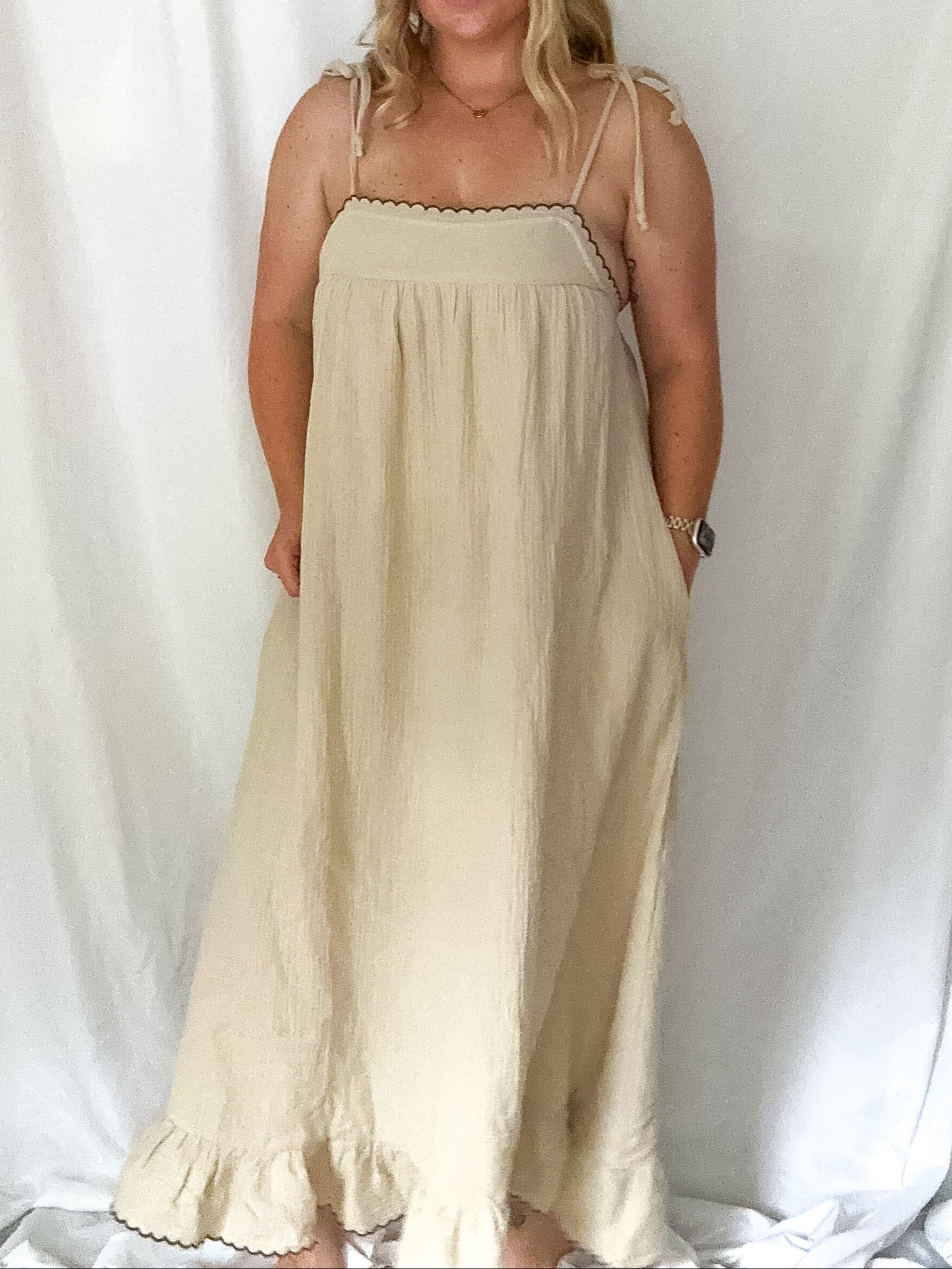 Woman wearing a beige dress against a white background