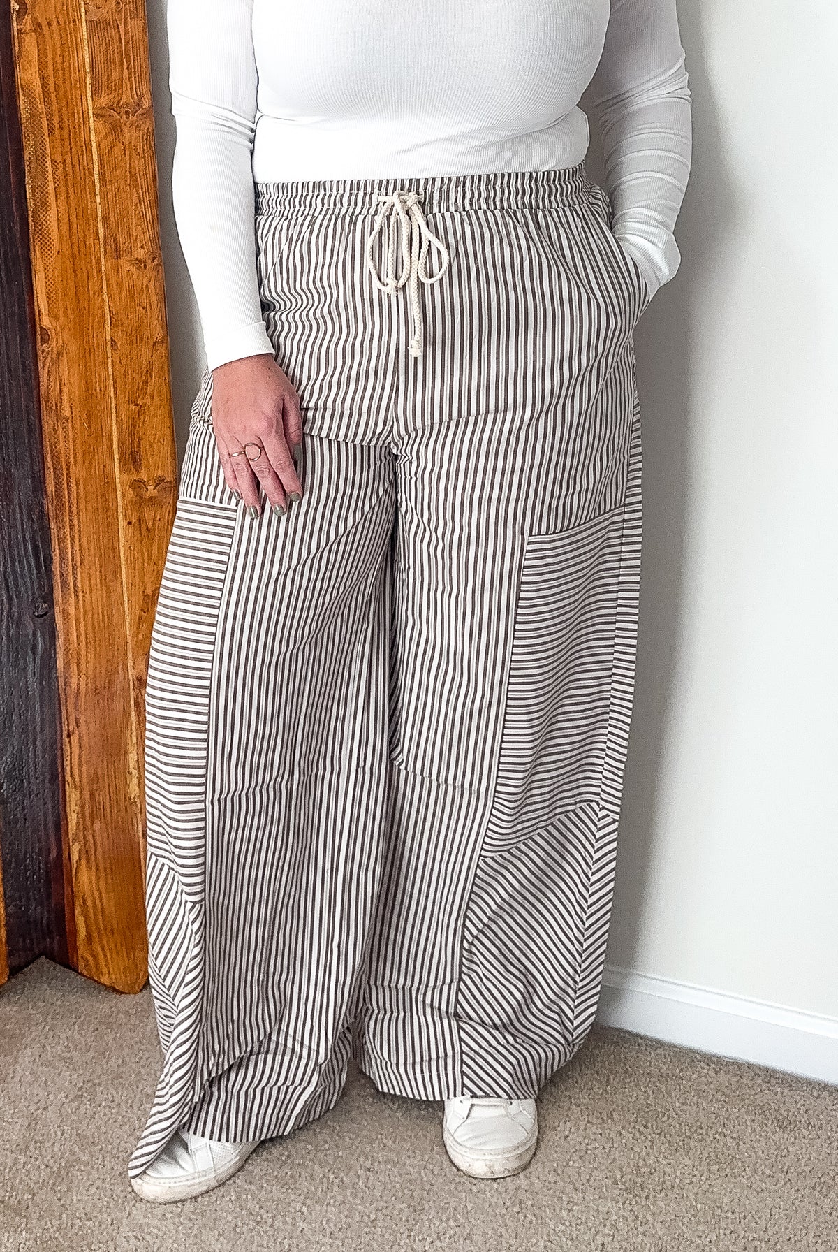 Wide-leg pants with mixed stripe pattern in brown, featuring an elastic waistband and side pockets.