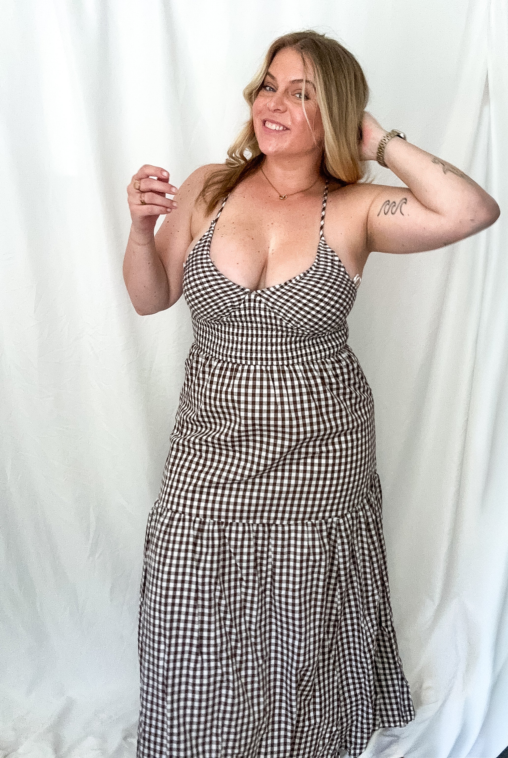 Woman wearing a black and white checkered dress against a white background