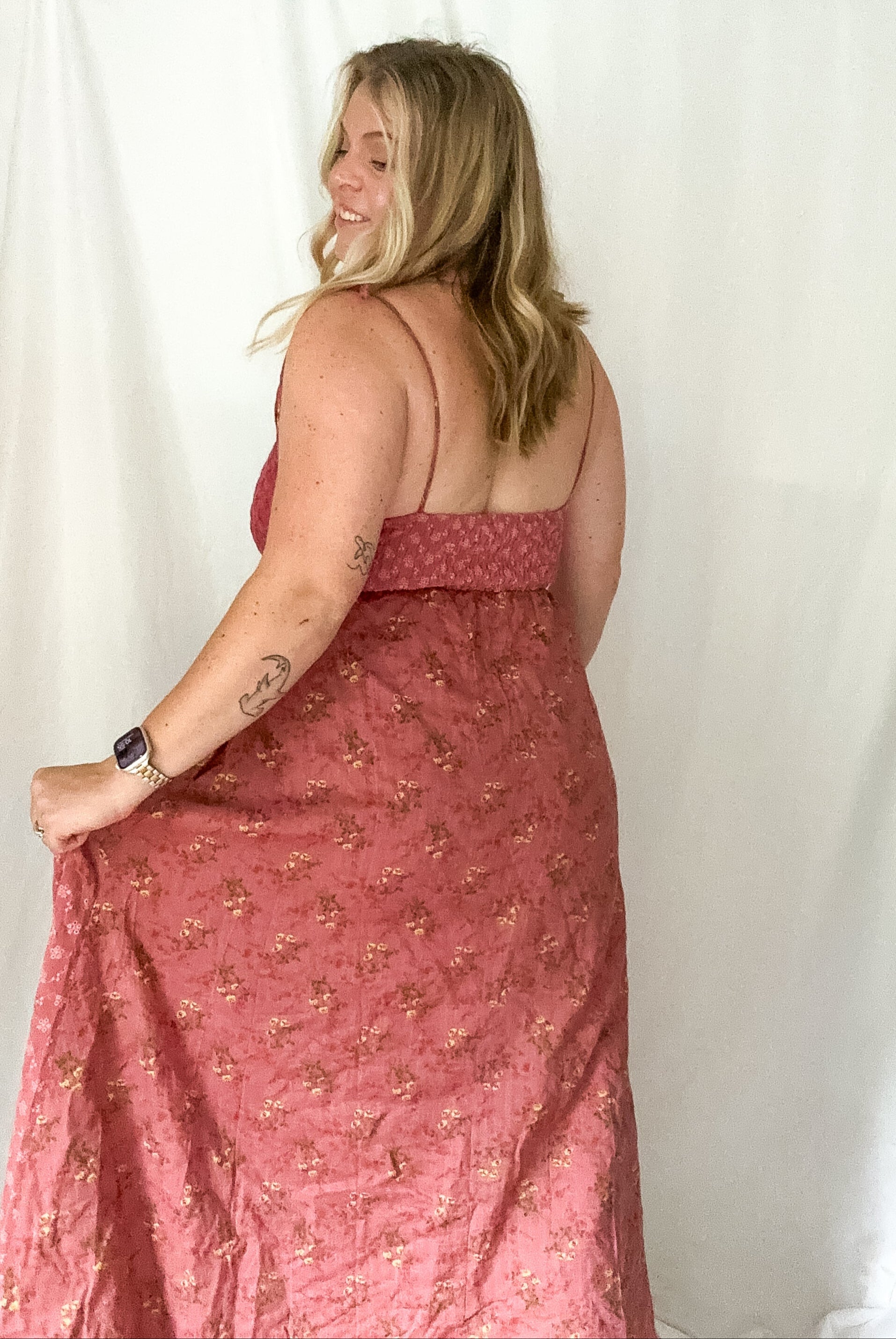 Woman wearing a pink floral dress against a white background