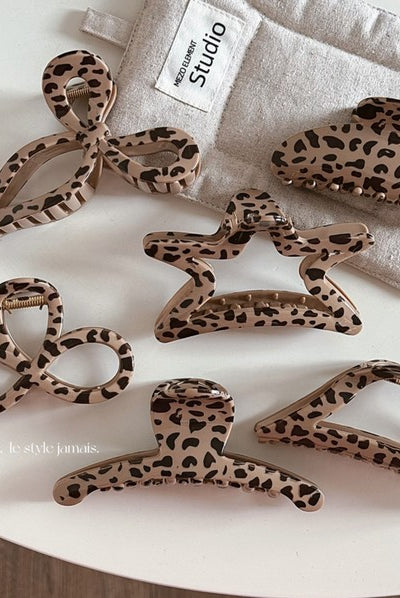 A 3.5-inch hair claw with a bold leopard print design, shown on a table.