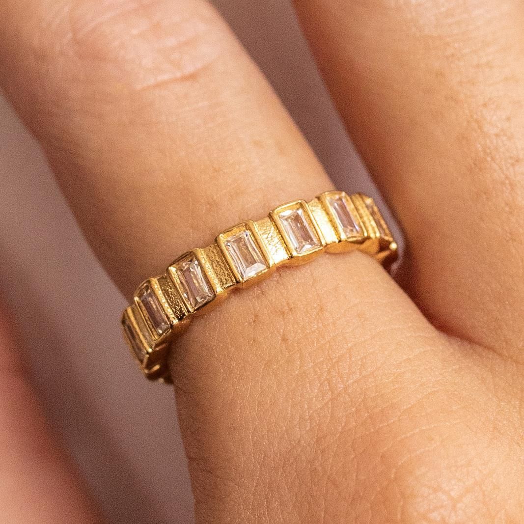 A gold-plated stainless steel ring with hypoallergenic cubic zirconia stones set on it.