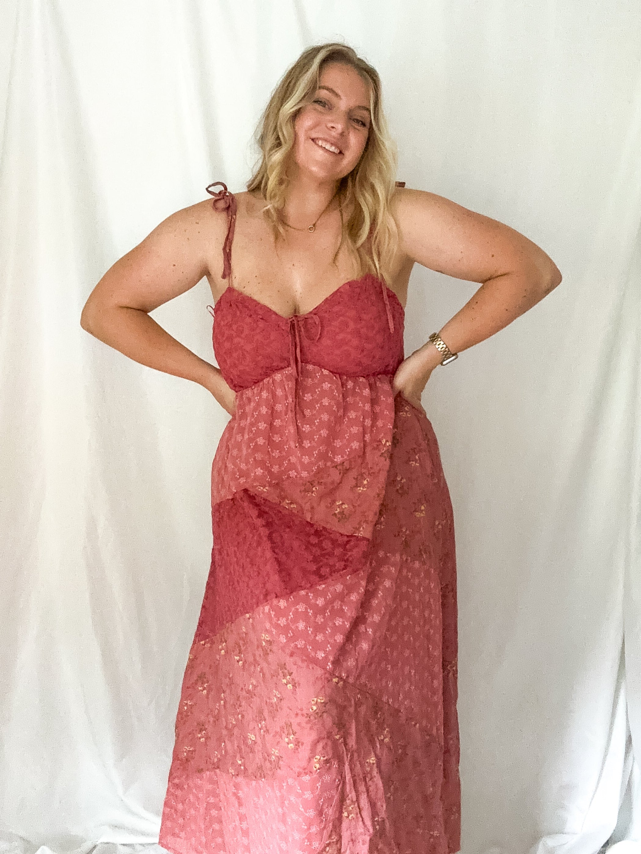 Woman wearing a red patterned dress against a white background