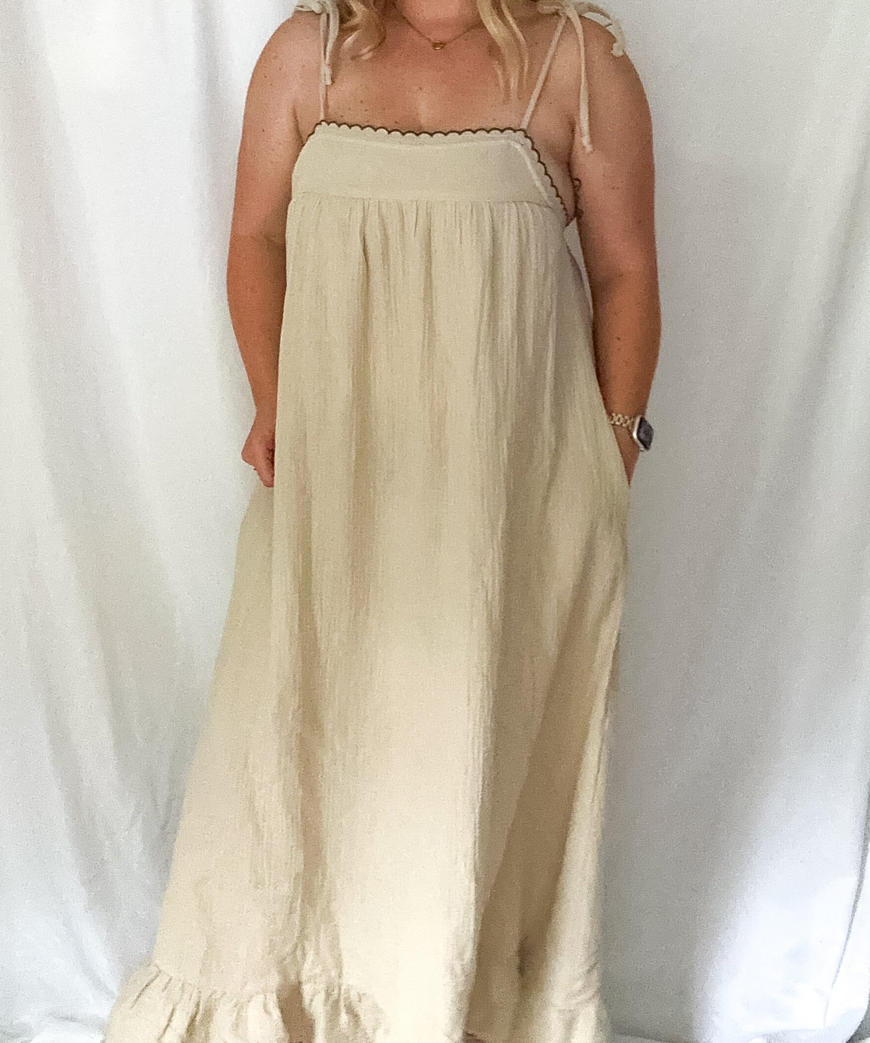 Woman wearing a beige dress against a white background