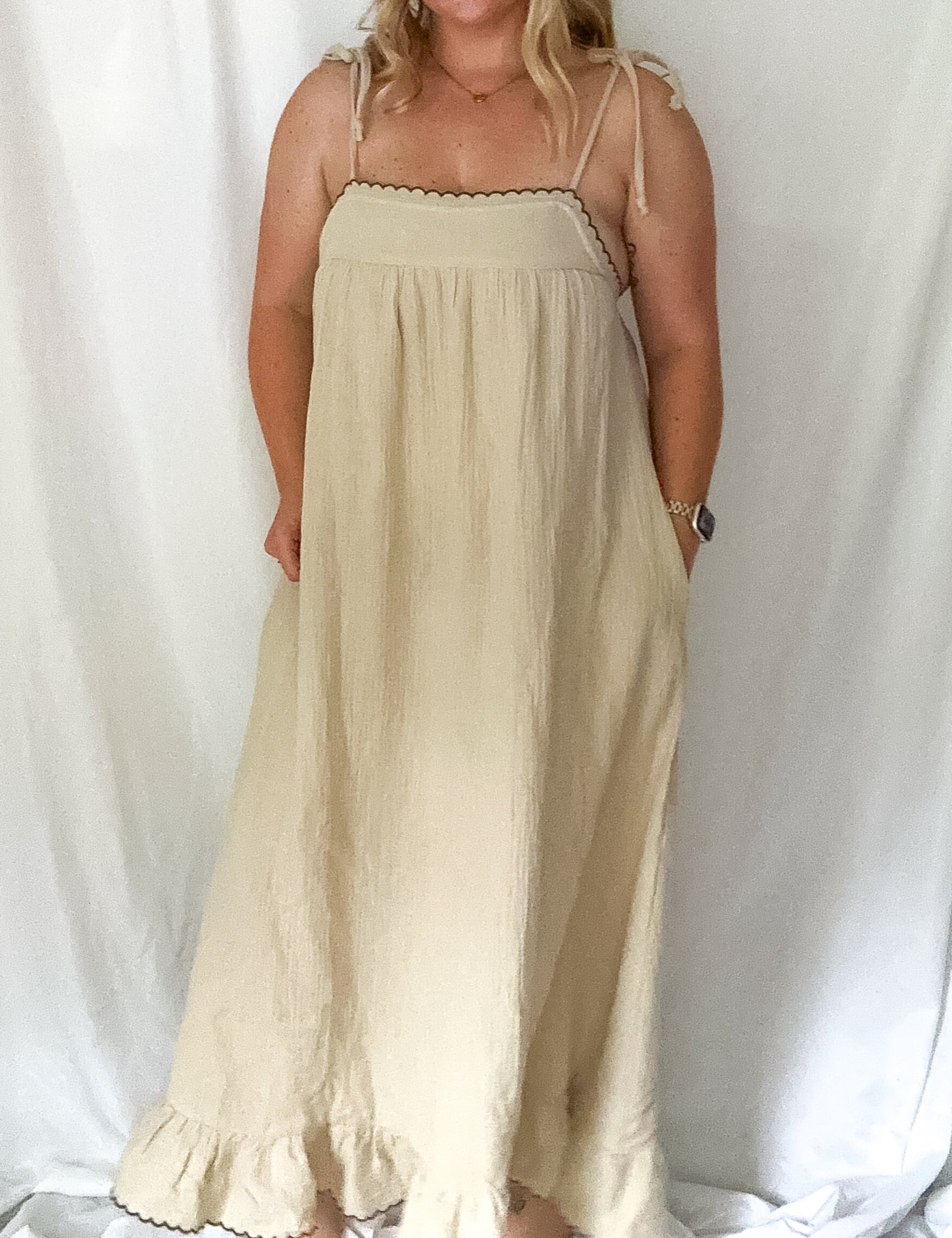 Woman wearing a beige dress against a white background