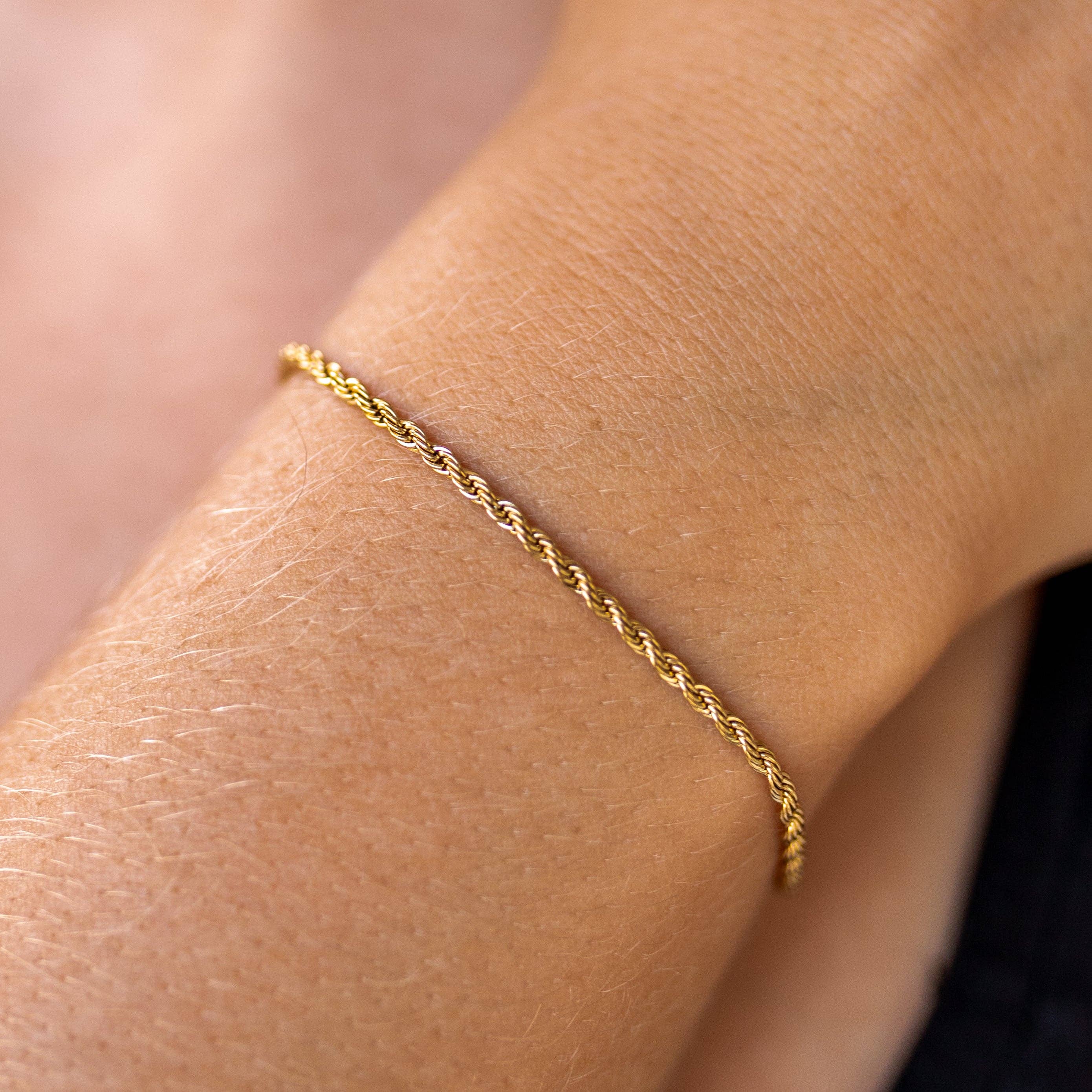 Gold bracelet on a wrist with a blurred background