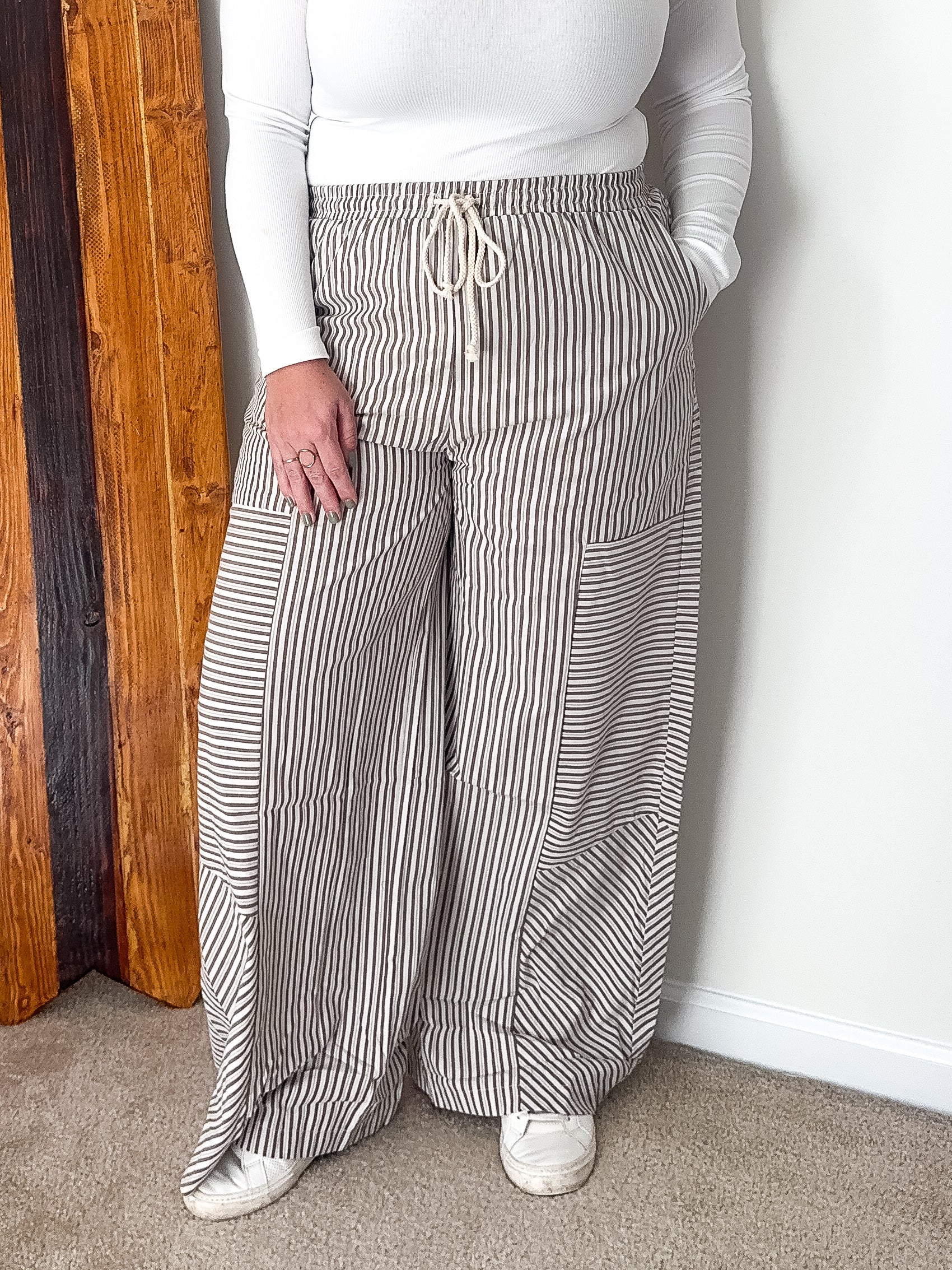 Wide-leg pants with mixed stripe pattern in brown, featuring an elastic waistband and side pockets.