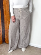 Wide-leg pants with mixed stripe pattern in brown, featuring an elastic waistband and side pockets.