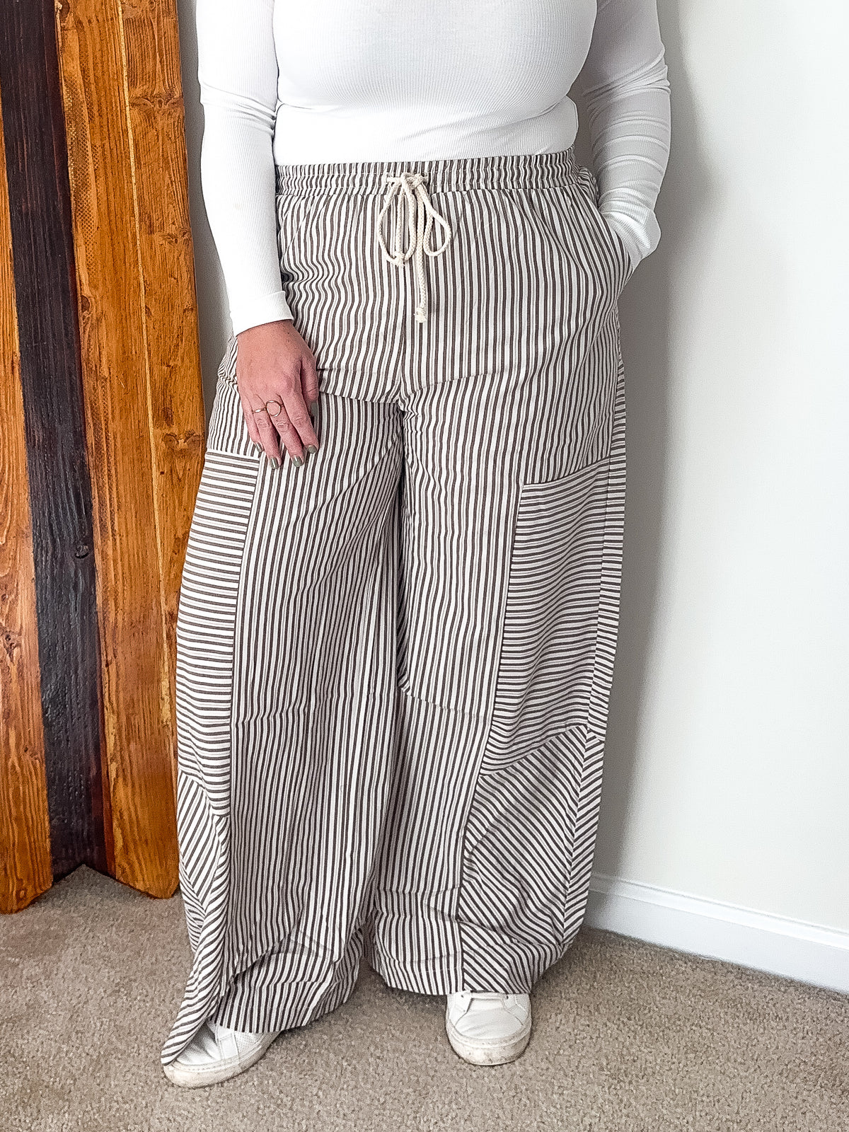 Wide-leg pants with mixed stripe pattern in brown, featuring an elastic waistband and side pockets.