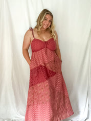 Woman wearing a red patterned dress against a white background