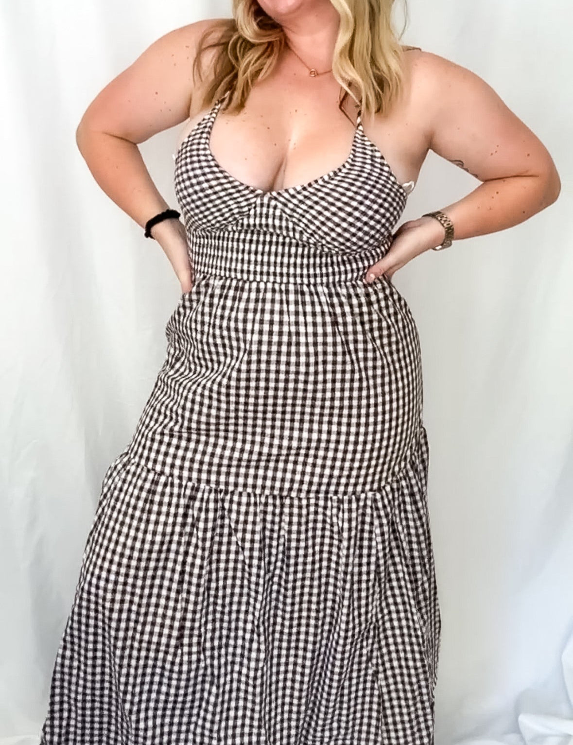 Woman wearing a black and white checkered dress against a plain background