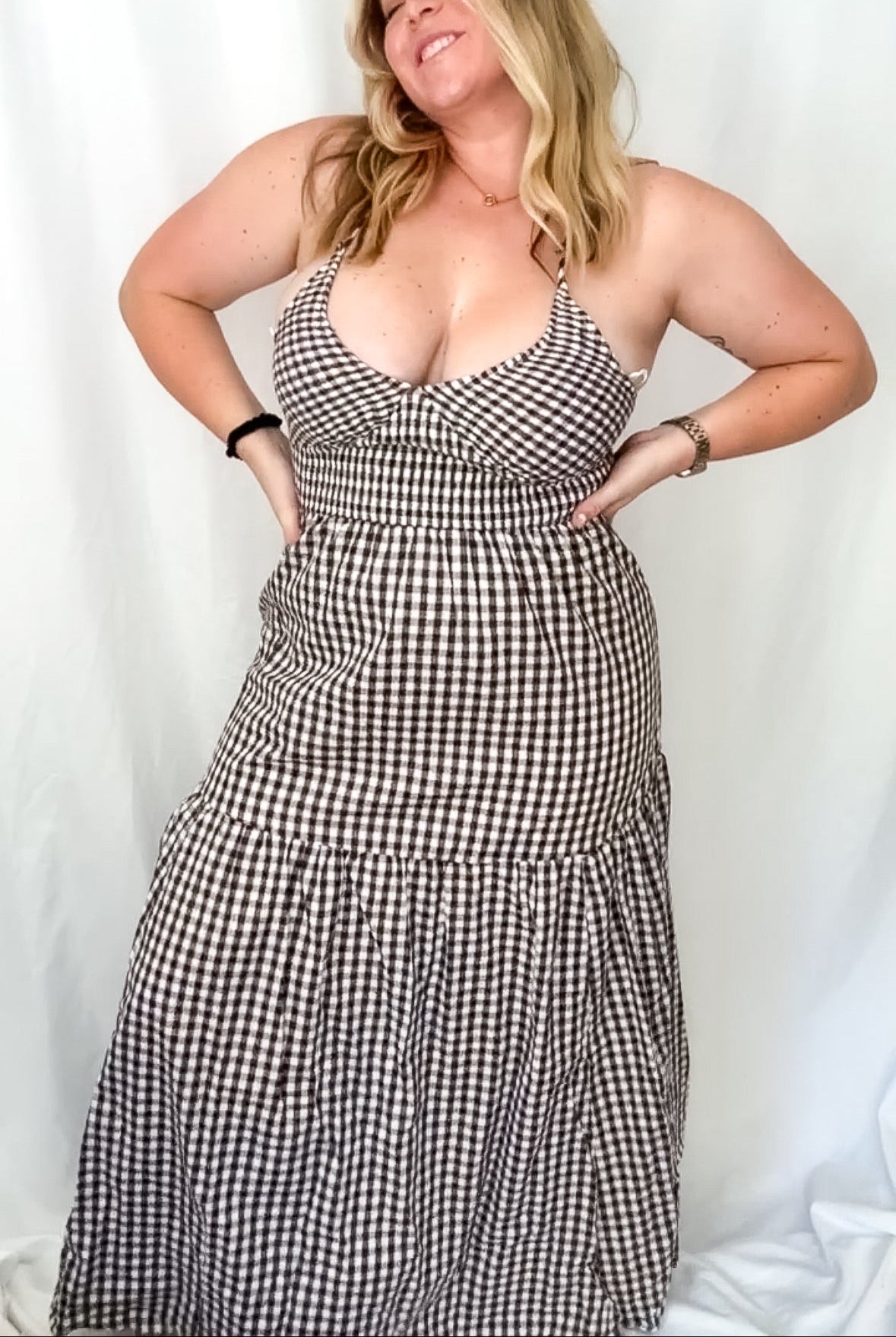 Woman wearing a black and white checkered dress against a plain background