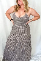 Woman wearing a black and white checkered dress against a plain background