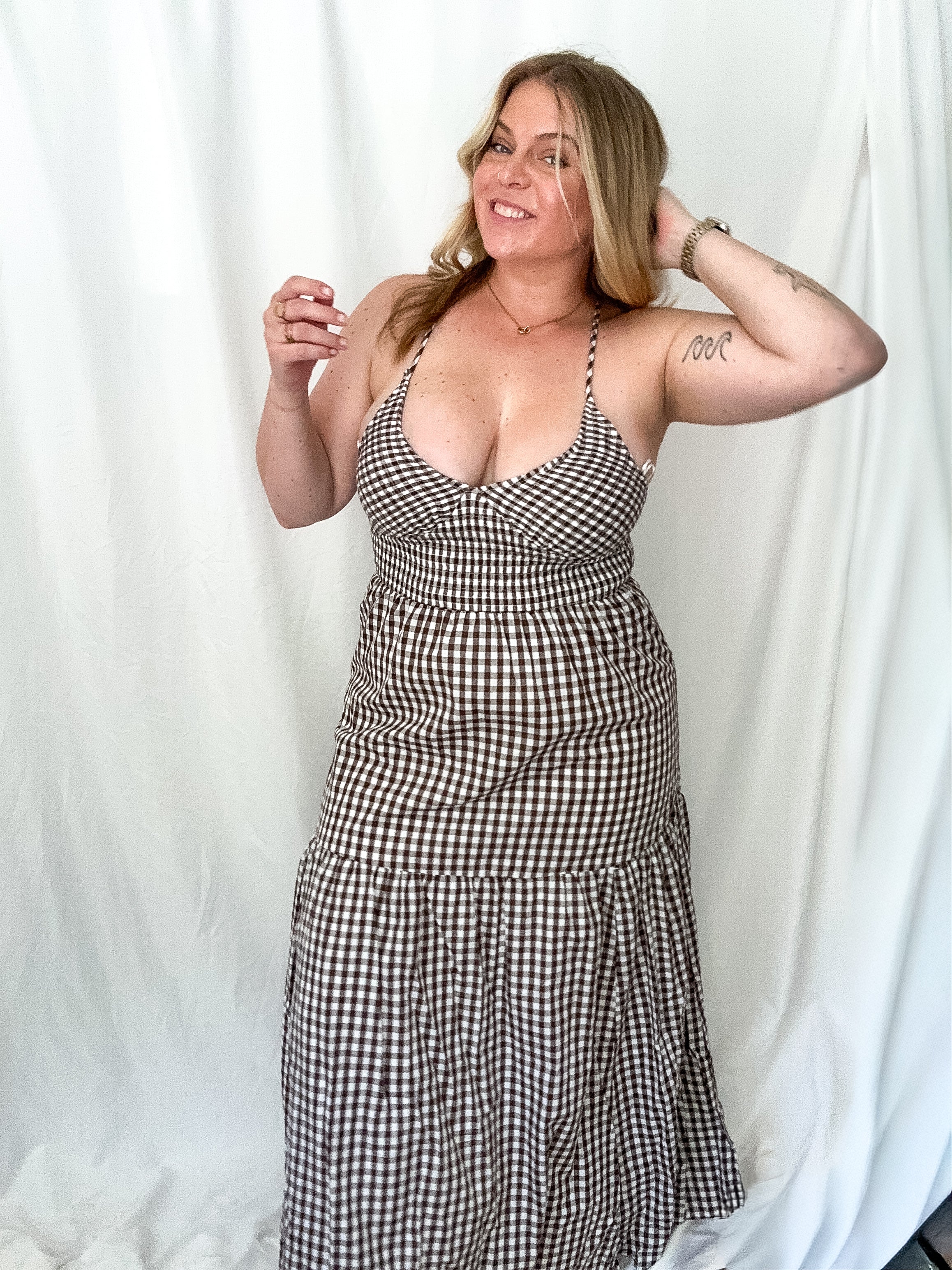 Brown gingham maxi dress with a smocked bodice, adjustable straps, and a deep V-neckline.