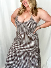 Woman wearing a black and white checkered dress against a plain background