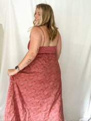 Woman wearing a pink floral dress against a white background