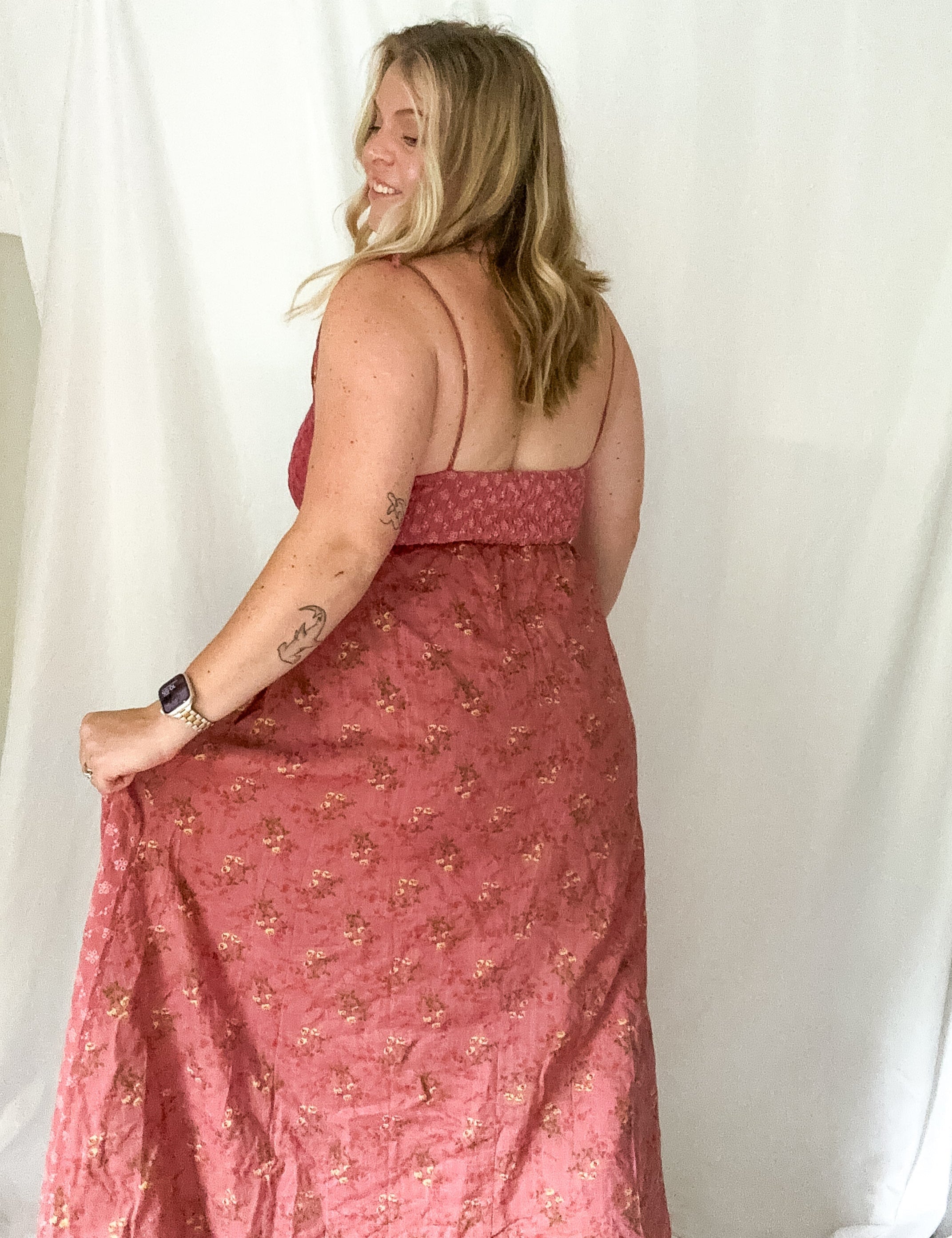 Woman wearing a pink floral dress against a white background