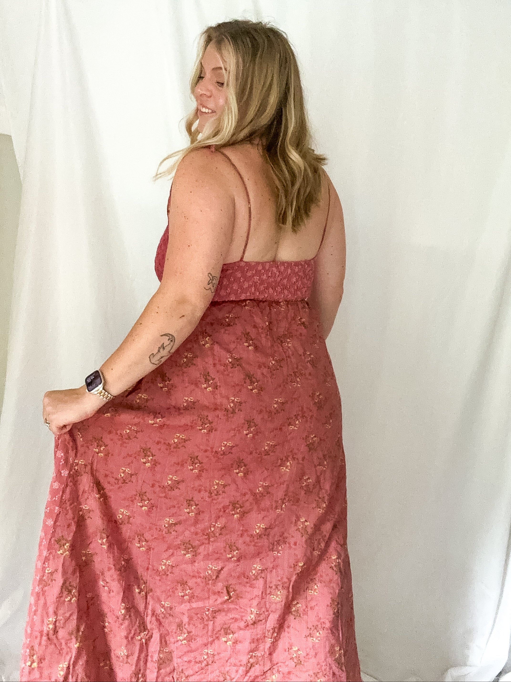 Woman wearing a pink floral dress against a white background