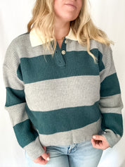 Person wearing a striped sweater with green and gray horizontal stripes on a white background