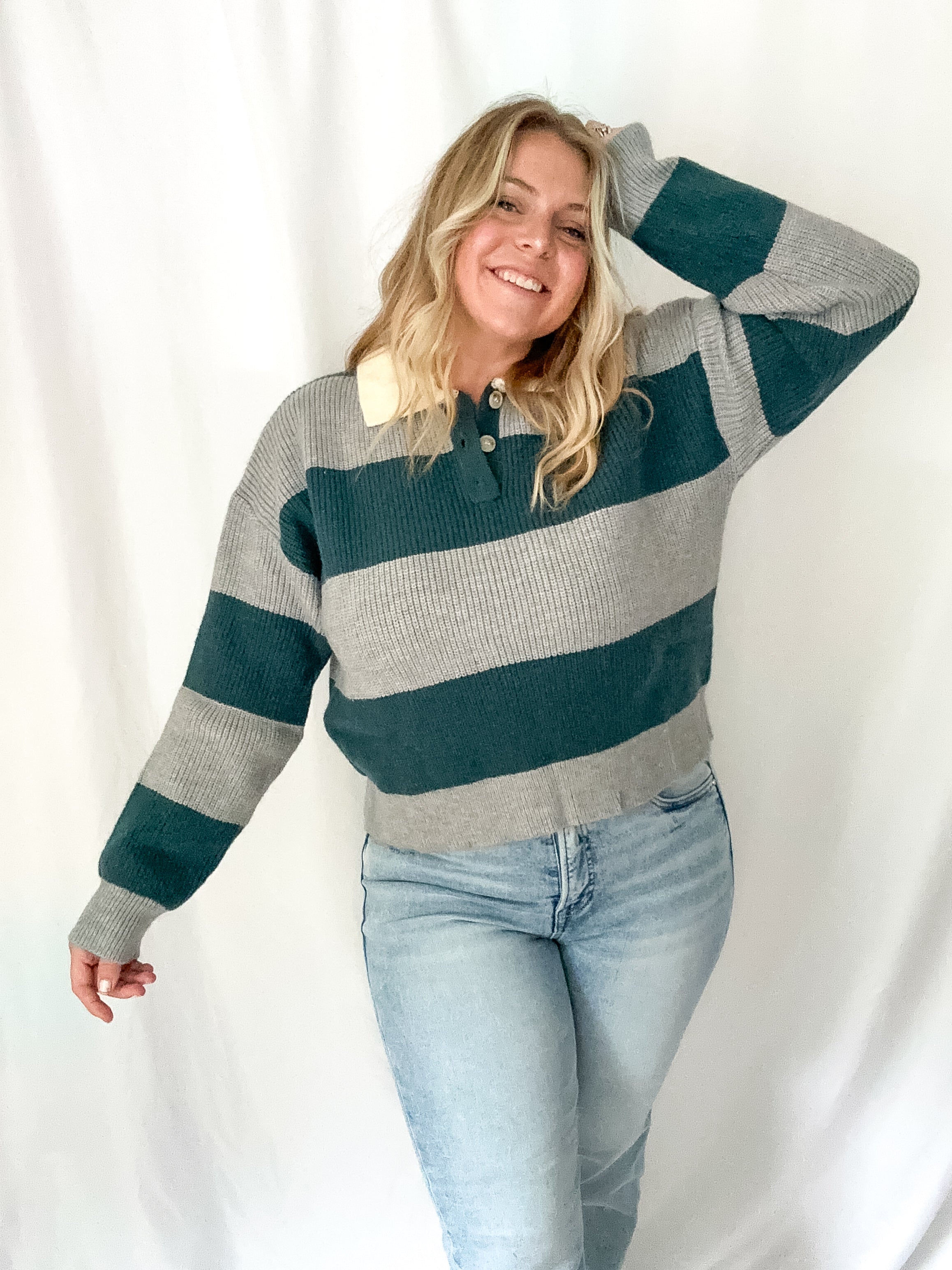 Woman wearing a striped sweater and jeans against a white background