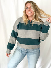 Woman wearing a striped sweater and jeans against a white background
